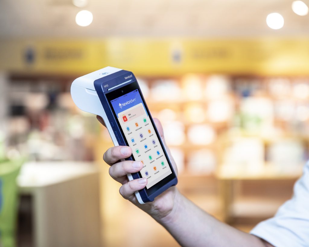 Hand holding an Android POS terminal in a shop