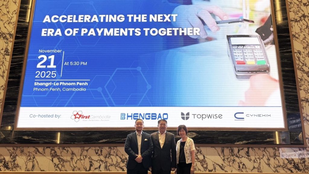 The event screen for Accelerating the Next Era of Payments Together, 21 November 2025 at Shangri-La Phnom Penh, co-hosted by First Cambodia, Hengbao, Topwise and CYNEXIX, with three guests in front.
