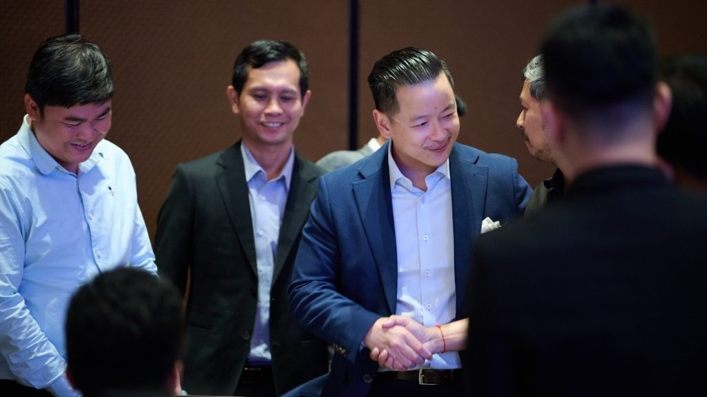 Guests greeting each other with a handshake at the event.