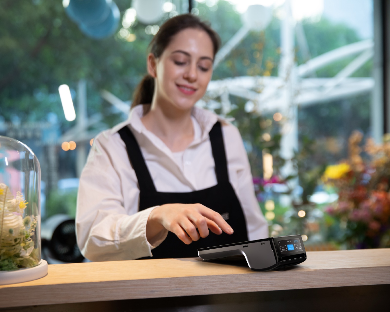 Café staff member taking a payment on a countertop terminal