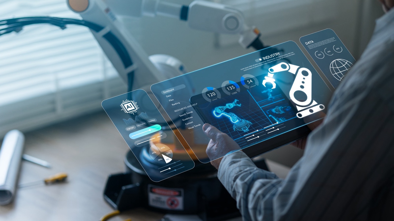 A person holding a tablet with an AI and industrial robotics dashboard, next to a robot arm.